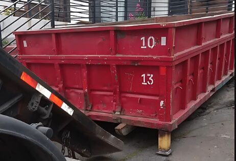Red roll-off dumpster positioned in a driveway for a Longview, TX renovation project