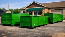 Green roll-off dumpsters lined up outside a Longview business location